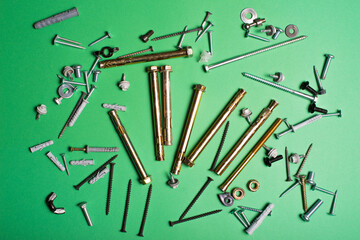 Photo of different types of screws over green background.