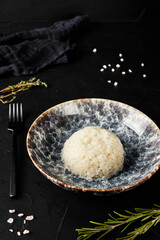 rice in a plate on black textured background
