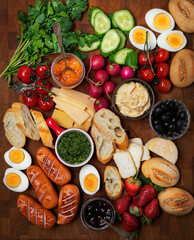 Breakfast or brunch board for the whole family with sauseges, eggs, breads and vegetables