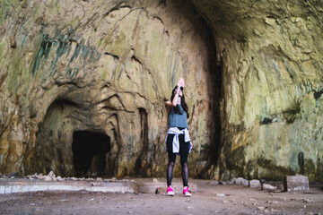 Obraz na płótnie Canvas Girl make photo with smartphone in font of devetashka cave near lovech 