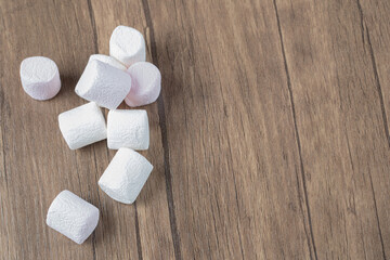 Yummy marshmallows isolated on a wooden table
