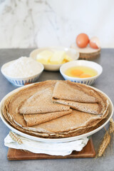 A traditional French breton buckweat 
 crepe or savory galettes  (crêpes salées) with ingredients such as flour, eggs and butter on a table 