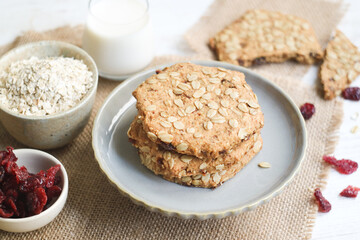 Fototapeta na wymiar A healthy and organic low calories oatmeal cookies in plate with milk and dried cranberries in frame, diet with high fiber concept to lower glycemic index in boday