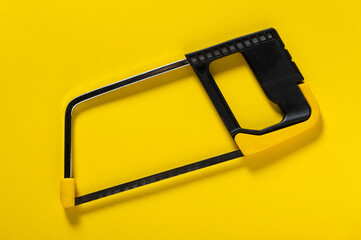 Hacksaw for metal on a yellow background. Applied by craftsmen to repair plumbing or construction