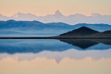 Fototapeta na wymiar Lake Tuzkol in Kazakhstan and a view of Khan Tengri peak at sunrise reflection of a mountain peak in the lake.