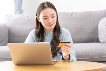 クレジットカードを使用する若いアジア人女性