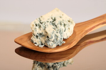 Ein Stück Blauschimmelkäse auf einem Holzlöffel