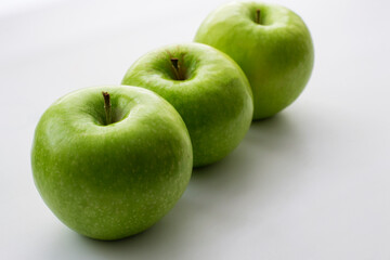 Ripe green apples on a white window. Juicy fruits on a white background.