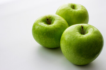 Ripe green apples on a white window. Juicy fruits on a white background.