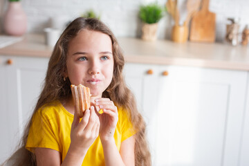 Portrait of two teenage beautiful smiling hipster girls in fashionable clothes. carefree children posing against the backdrop of the kitchen. Positive models have fun with sweets.