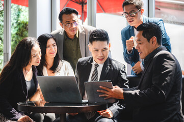 From above of group of diverse colleagues in formal clothing discussing business ideas while gathering at table in modern office and working together