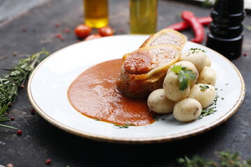 Stuffed cabbage with minced meat in tomato sauce served with potatoes.
Ready dish served on a plate. Serving proposal, culinary photography.