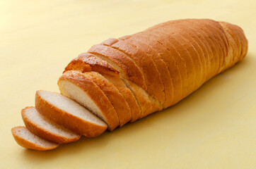 Closeup of sliced whie bread on the bright yellow surface