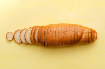 Top view of whole white bread.Slices of white bread on the yellow background