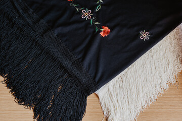 Un mantón de manila blanco y otro negro bordado con estampado floral. Concepto de baile típico...