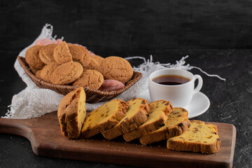Close of photo of cup of tea. Black background with fresh homemade cookies