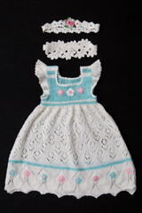 Woolen dress made of lace lies on a black background