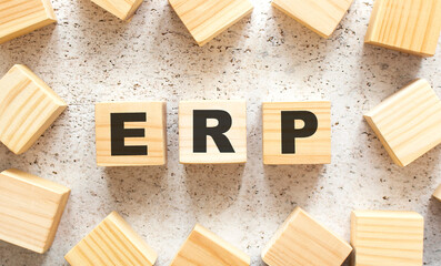 The word ERP consists of wooden cubes with letters, top view on a light background.