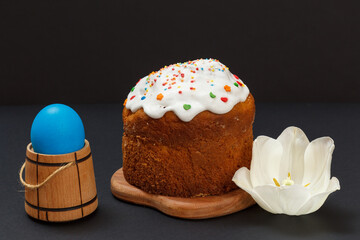 Easter cake and colorful Easter egg in wicker basket.