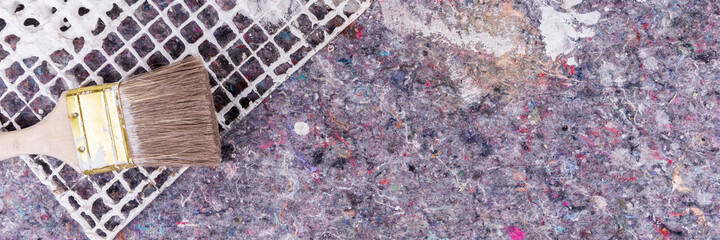 Panorama. Painter fleece with spots of paint and wooden paintbrush