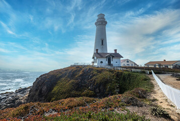 Fototapeta na wymiar Pigeon Point lighthouse against the backdrop of a beautiful sky and ocean with waves, a great landscape of the Pacific coast in California