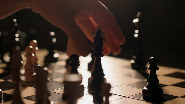 Close-up female player makes a move, the chess piece queen hits bishop. Intellectual pastime in quarantine