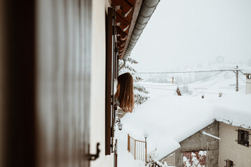 Femme penchée à la fenêtre du chalet