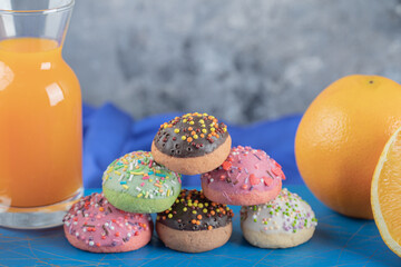 Fresh orange juice and homemade cookies on blue wooden board