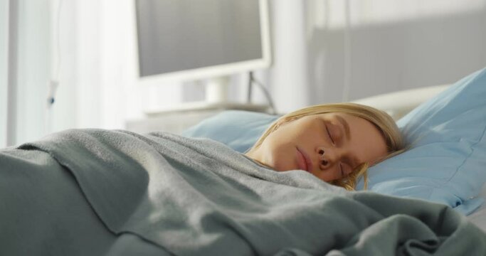 Close up of sick young woman sleeping in hospital bed