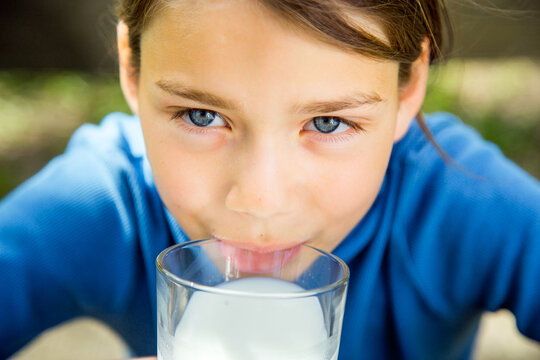 Portrait Of A Healthy Child With A Glass Of Milk. A Boy Is Drinking Milk In Nature.