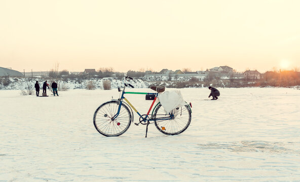 Bicicletă retro, vintage, pentru pescuitul de iarnă. pe un lac înghețat iarna. pescarii pescuiesc în fundal