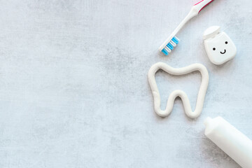 Fototapeta na wymiar Tooth shape with tube of toothpaste and toothbrush. Dental hygiene concept, top view