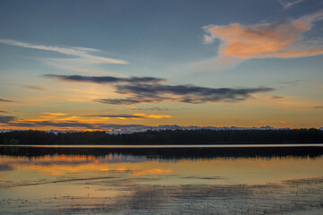 Beautiful sunset landscape over a Finnish lake. The space is flooded with gold.