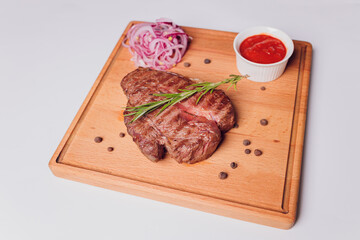 Large meat steak on the bone, grilled, served with grilled vegetables, corn, red onion, sweet...