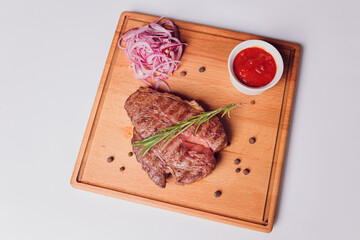 Large meat steak on the bone, grilled, served with grilled vegetables, corn, red onion, sweet...