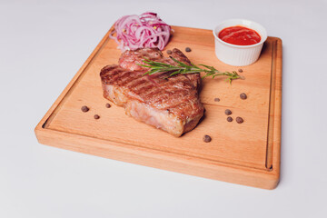 Large meat steak on the bone, grilled, served with grilled vegetables, corn, red onion, sweet...
