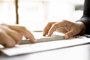 Business men are handing over large dollar bills to their business partners as money for bribery in order to cheat companies, corruption is illegal and immoral. The concept of corruption.