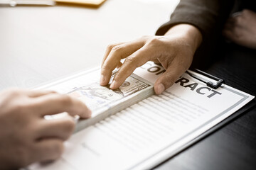 Business men are handing over large dollar bills to their business partners as money for bribery in order to cheat companies, corruption is illegal and immoral. The concept of corruption.