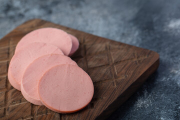 Close up photo of sliced salami on wooden board