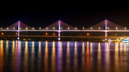 Fototapeta na wymiar Mandovi River Bridge in moonlight, with the reflection of coloured lights in the river. Locally known as Atal Setu, this is one of the largest cable-stayed bridge.