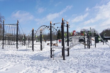 Children's playground  in a winter setting. Children's playground in a winter scenery. Family outdoors on a frosty sunny day 