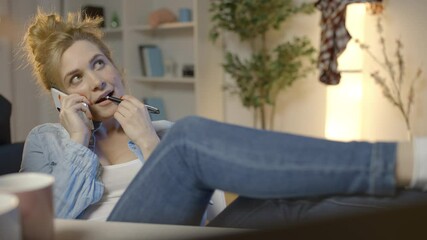 Young woman talking smartphone and laughing, putting legs on desk, laziness