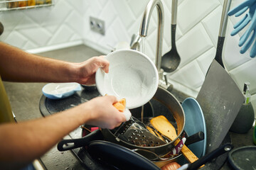 Young man washing dishes in the kitchen.