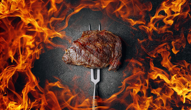 grilled cowboy beef steak on a dark background. expensive marbled beef of the highest grade fried to rare on the grill
