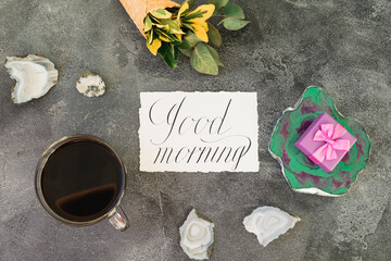 Gift box on resin art plate, paper card and coffee mug on gray background. Flat lay