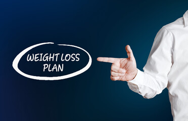 Male hand points to the word weight loss plan with an outline circle. Dieting plan