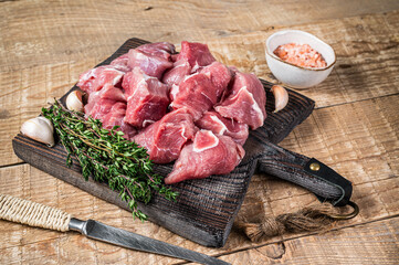 Fresh Raw Diced pork cubs meat with spices on a wooden butcher board. wooden background. Top view