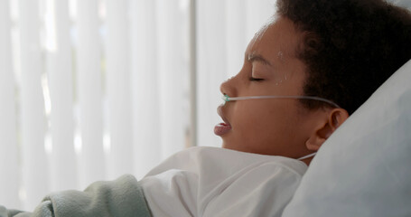Sick african kid having fever and sweating lying in hospital bed