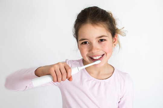 Child Brushing Their Teeth With Sonic Electric Tooth Brush Isolated On White Background. Oral Hygiene Concept With Copy Space