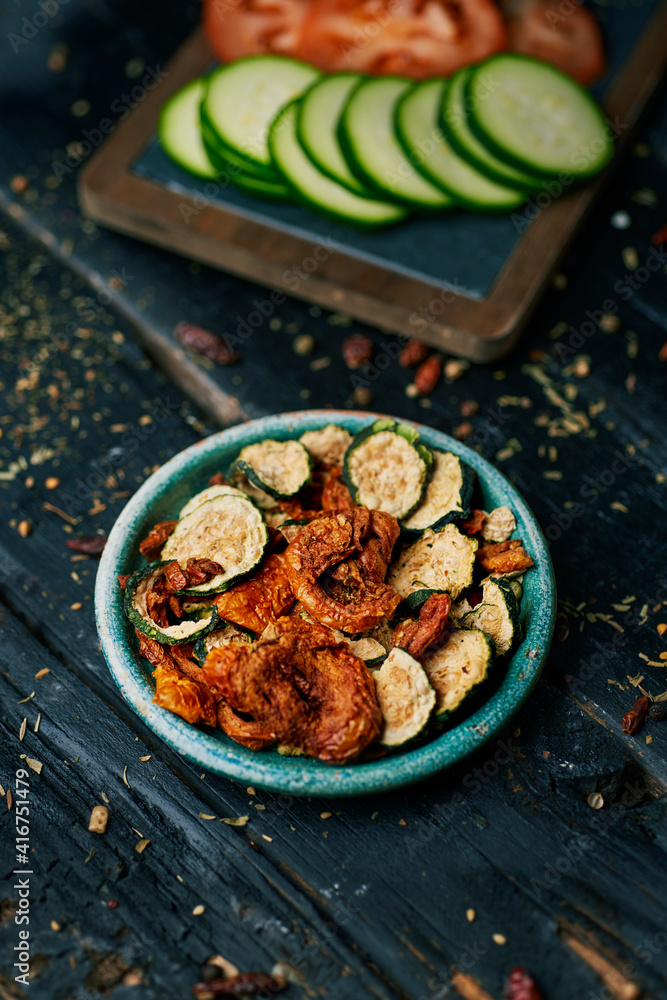 Poster some slices of dried tomato and zucchini